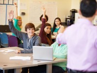 High School Students With Teacher In Class Using Laptops
