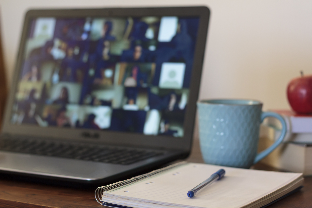 Close up of a desk scene with computer, note pad and coffee cup