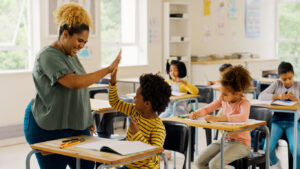 A teacher having a high five with her student in the classroom