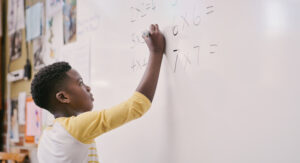 student solving math on whiteboard